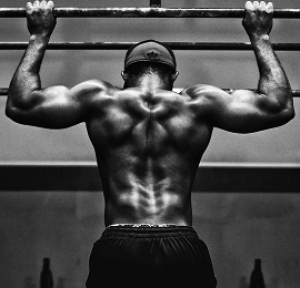 Strong muscular man, flexing his back muscles in grayscale